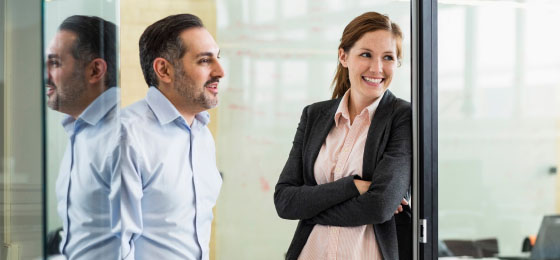 man and woman smiling in office setting