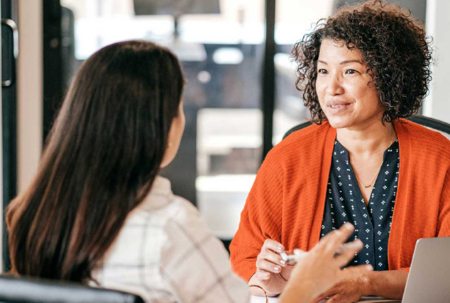 Two women have a discussion in an office