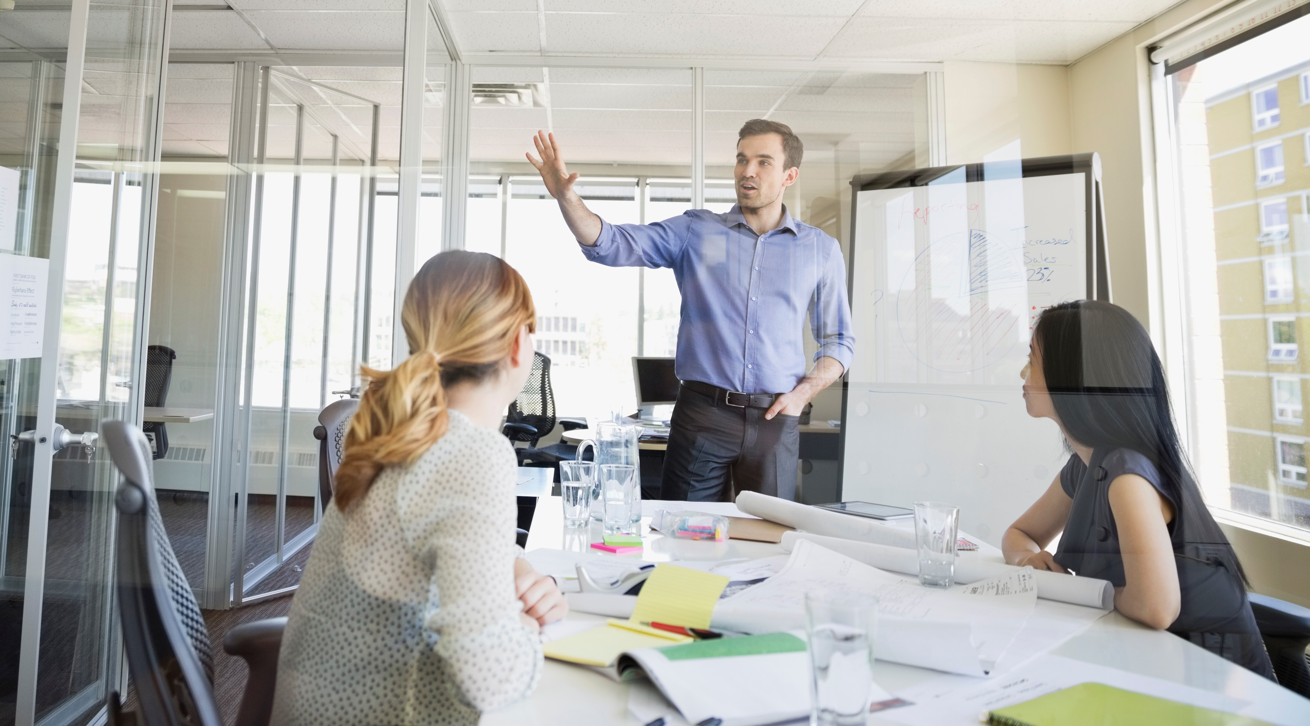 Man showing employees different graphs