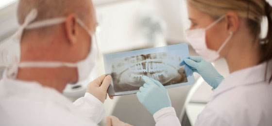 dentists holding an xray of a mouth