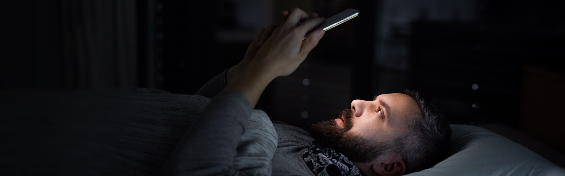 Man using phone in bed