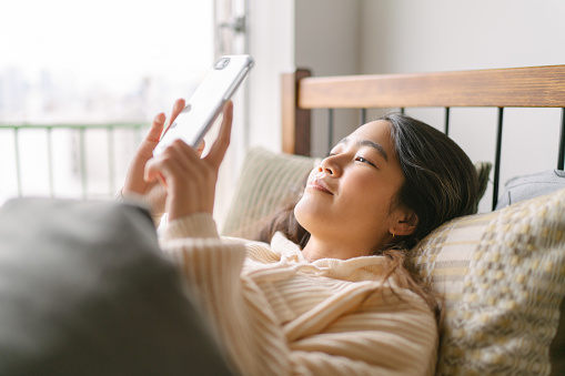 Women in bed with phone