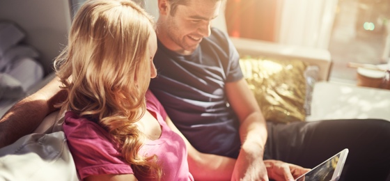 couple on the sofa holding a tablet